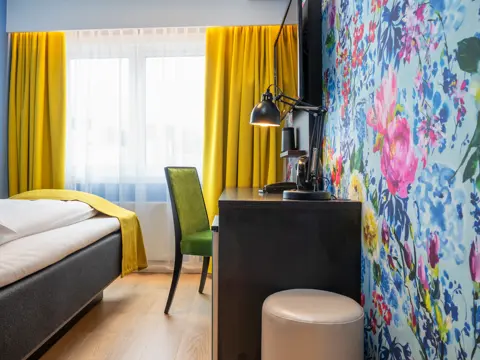 Seng, skrivebord,stol og blomstrete tapet på Thon Hotel Moldefjord