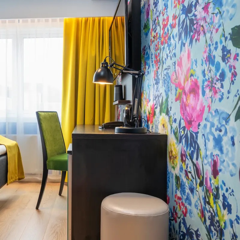 Seng, skrivebord,stol og blomstrete tapet på Thon Hotel Moldefjord