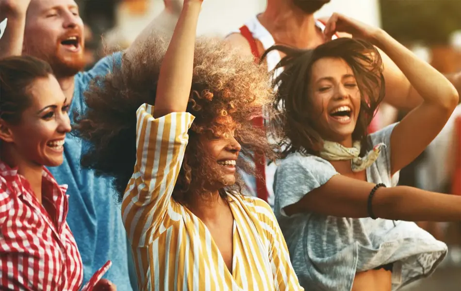 Glade mennesker i striper og ruter som ler og hopper