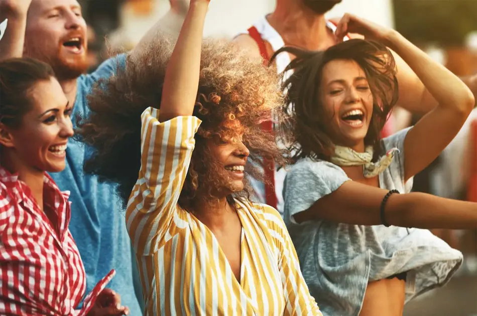 Glade mennesker i striper og ruter som ler og hopper