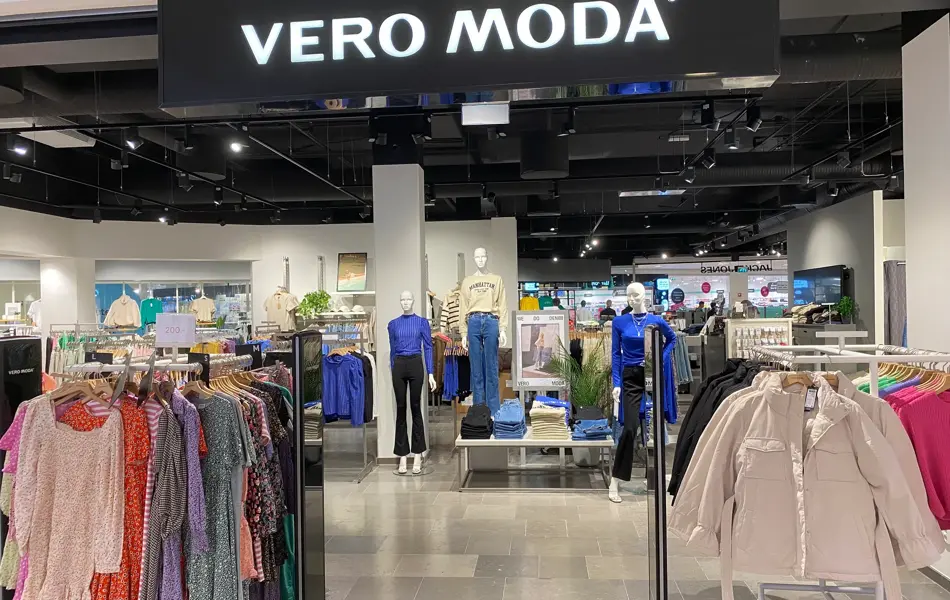 innendørs butikk med sort tak og klær og dukker