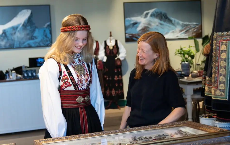 Hos Embla, jente i bunad prater med butikkmedarbeider