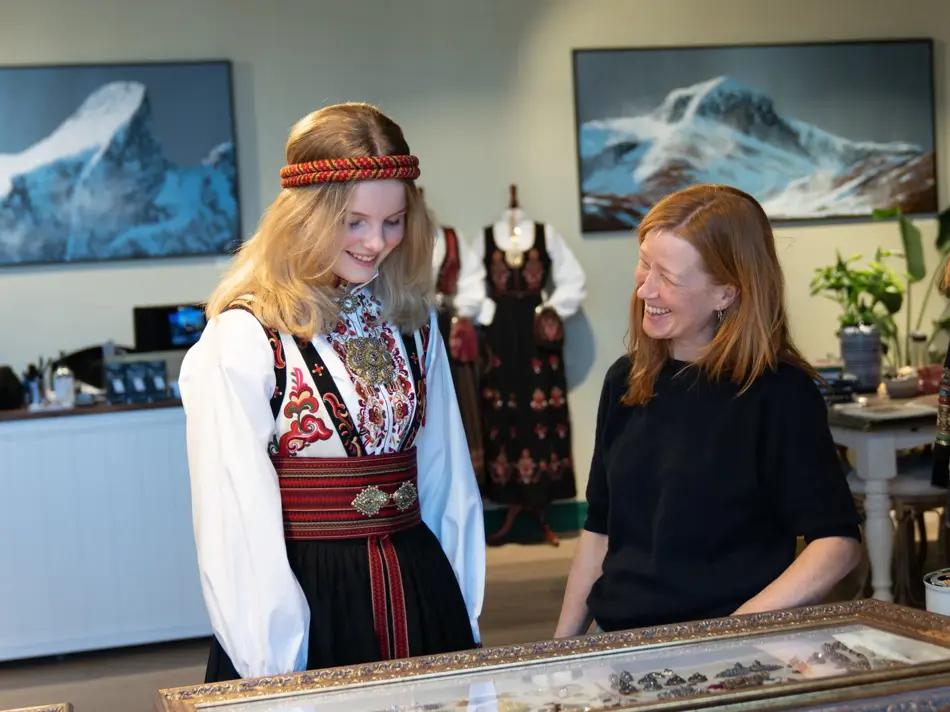 Hos Embla, jente i bunad prater med butikkmedarbeider