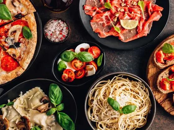 et bord med diverse italienske pasta retter, pizza og annet