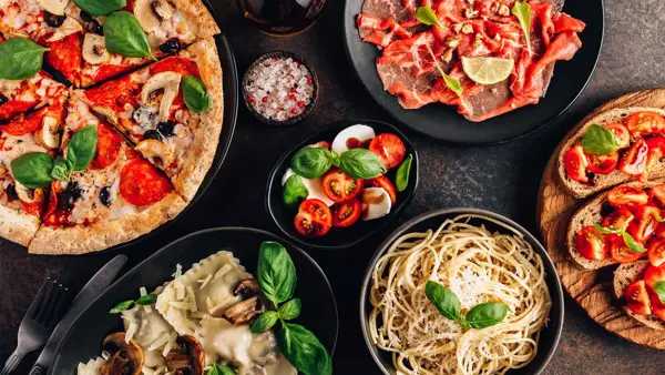 et bord med diverse italienske pasta retter, pizza og annet
