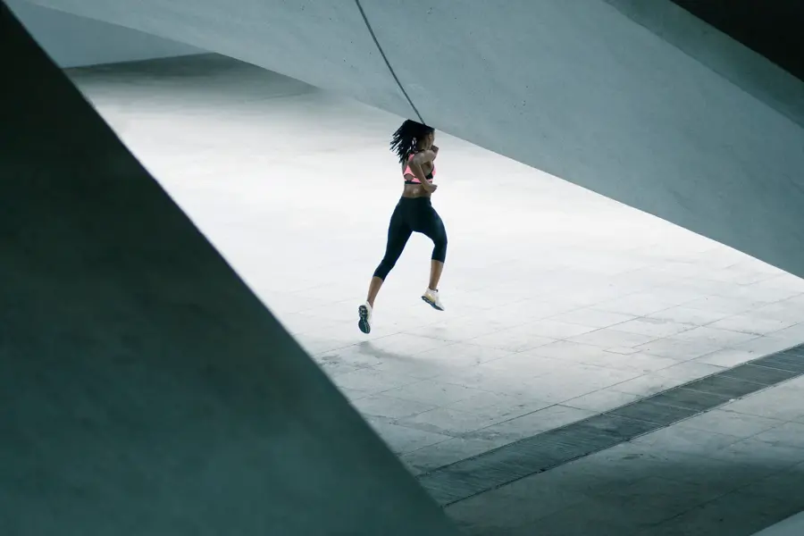 Mixed Race woman running under urban structure