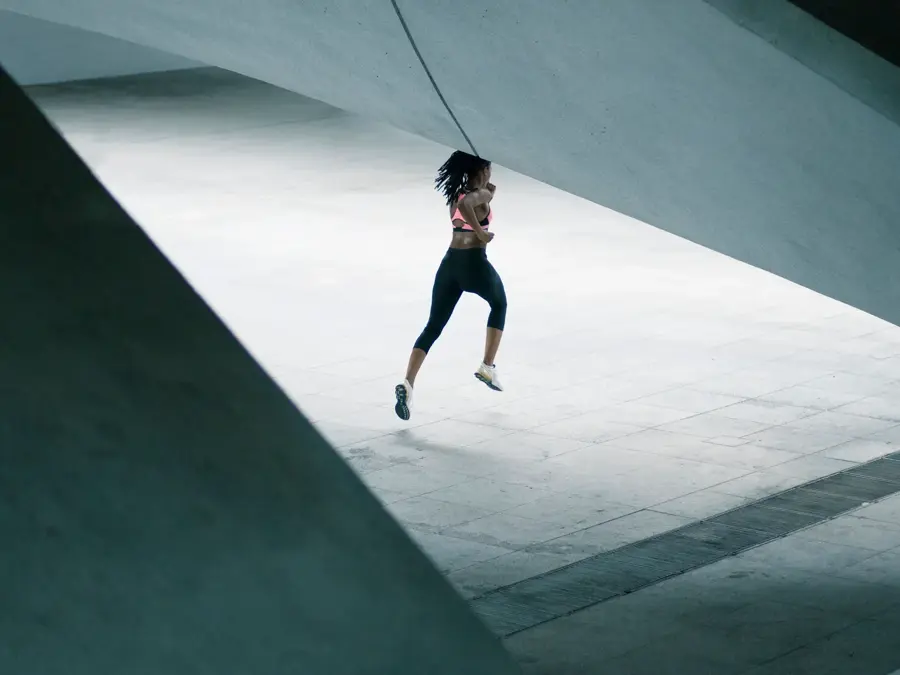 Mixed Race woman running under urban structure