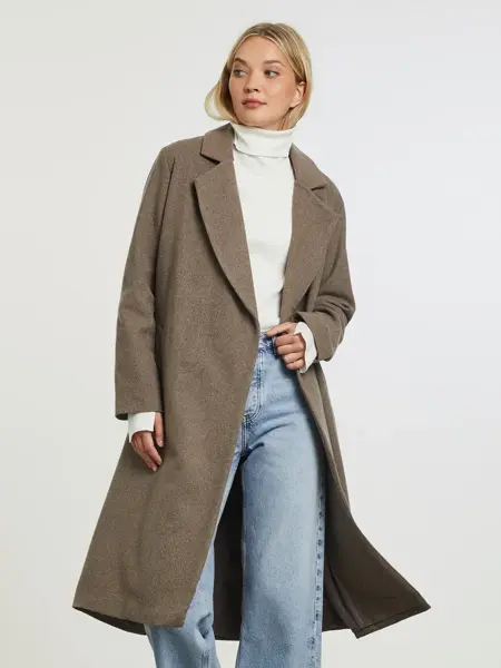 Modell som poserer i lang høstkåpe