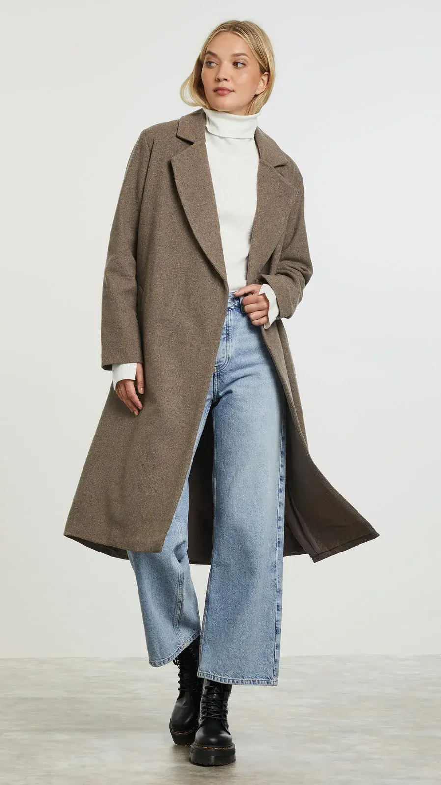 Modell som poserer i lang høstkåpe