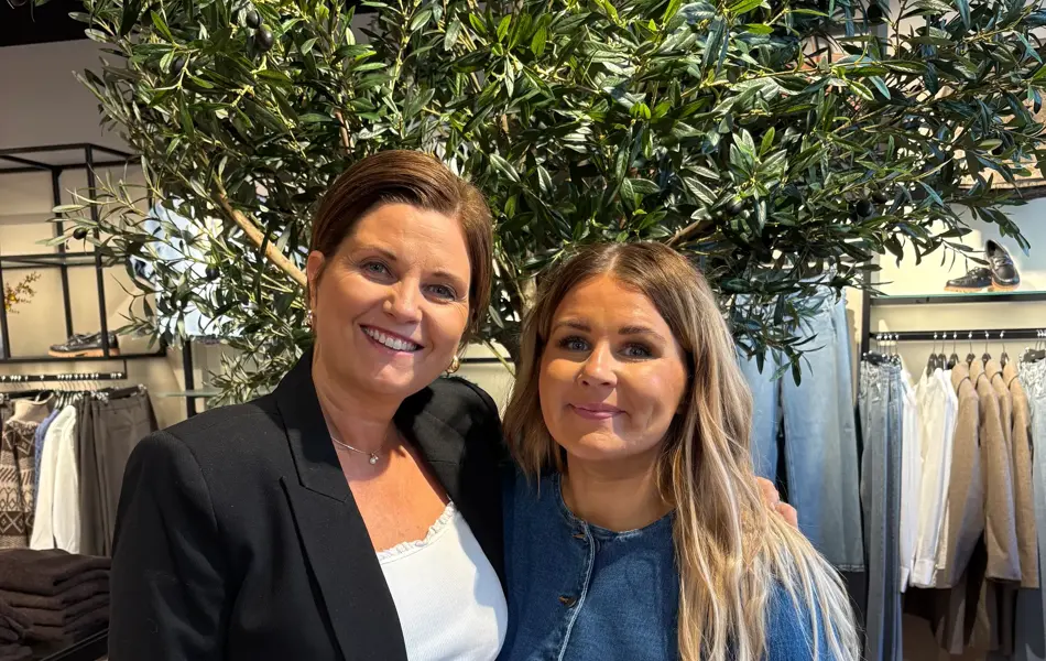 Dame med kort brunt hår og dame med langt lyst hår, kledd i sorte og hvite klær og ola klær