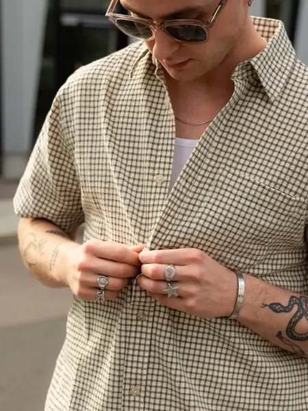 Mann som knepper opp en skjorte