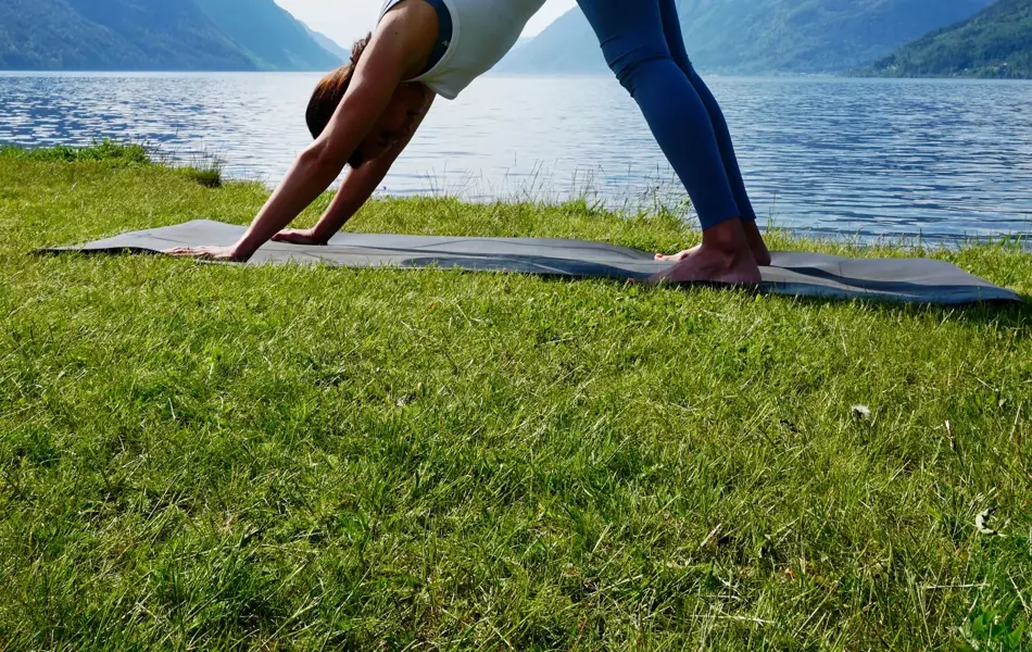 anny johansen viser yogaøvelser foran vakker fjord