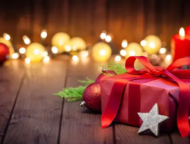 innpakket julegave på gulv med fine lys i bakgrunnen