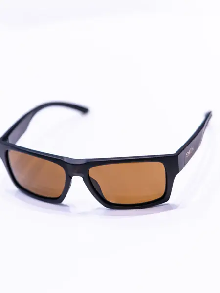 Brune solbriller som ligger på et hvitt bord med lysebrune brilleglass