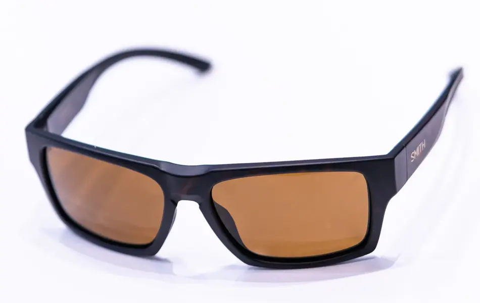 Brune solbriller som ligger på et hvitt bord med lysebrune brilleglass