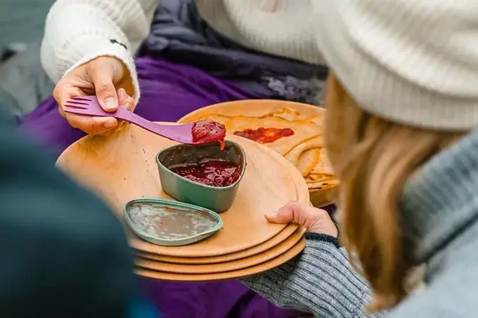 Syltetøyskål på et fat som noen tilbyr