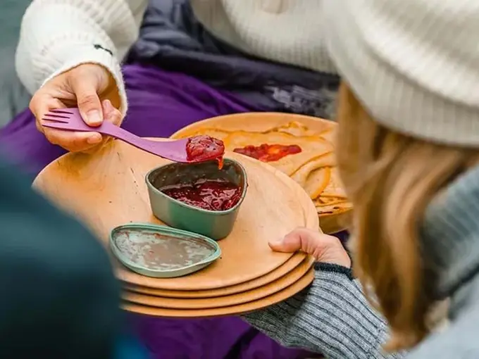 Syltetøyskål på et fat som noen tilbyr
