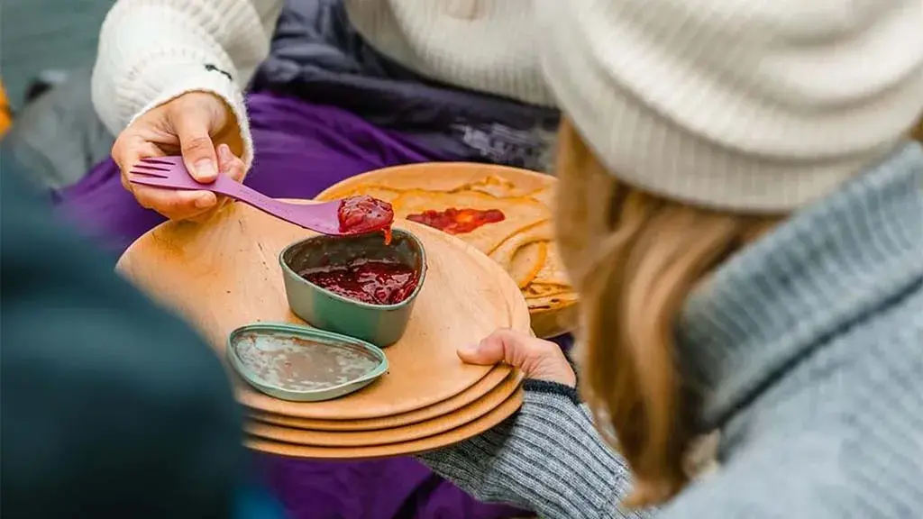 Syltetøyskål på et fat som noen tilbyr