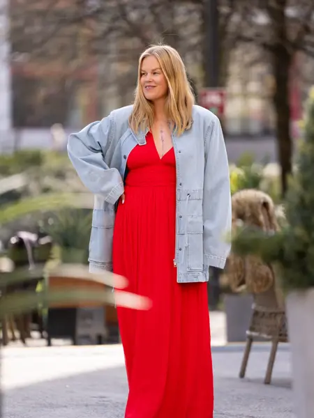 Dame i lang rød kjole og lang olajakke