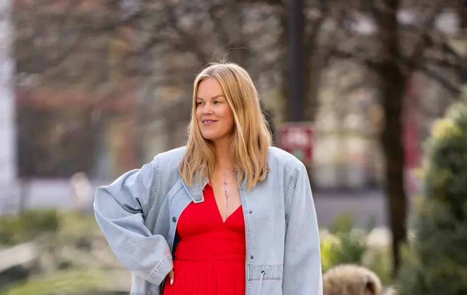 Dame i lang rød kjole og lang olajakke