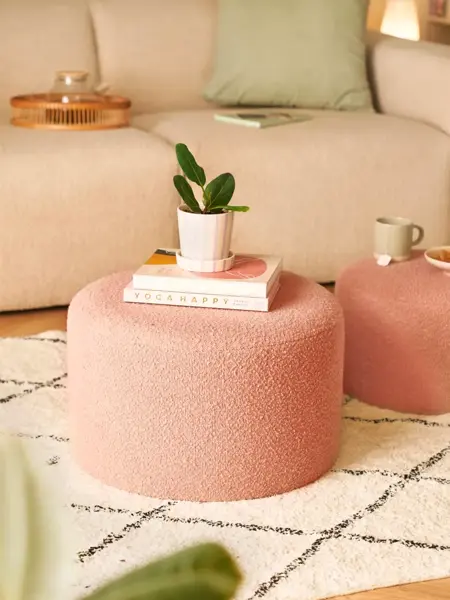 Interiørbilde i stue med ferskenfarget puff i sentrum.