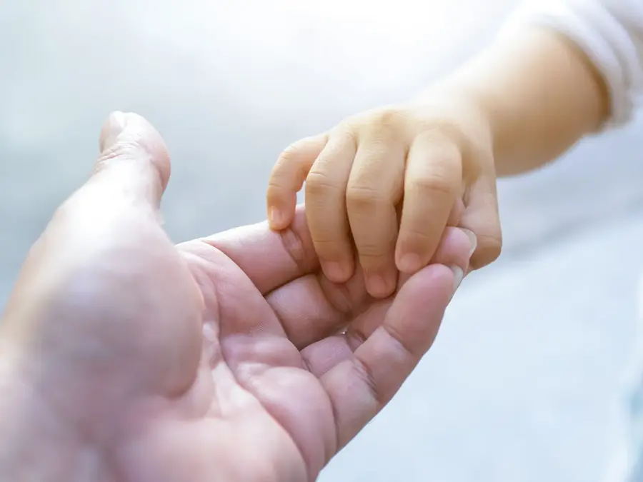 et barnehånd som holder i en voksen hånd