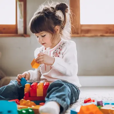 Sweet child playing with plastic blocks