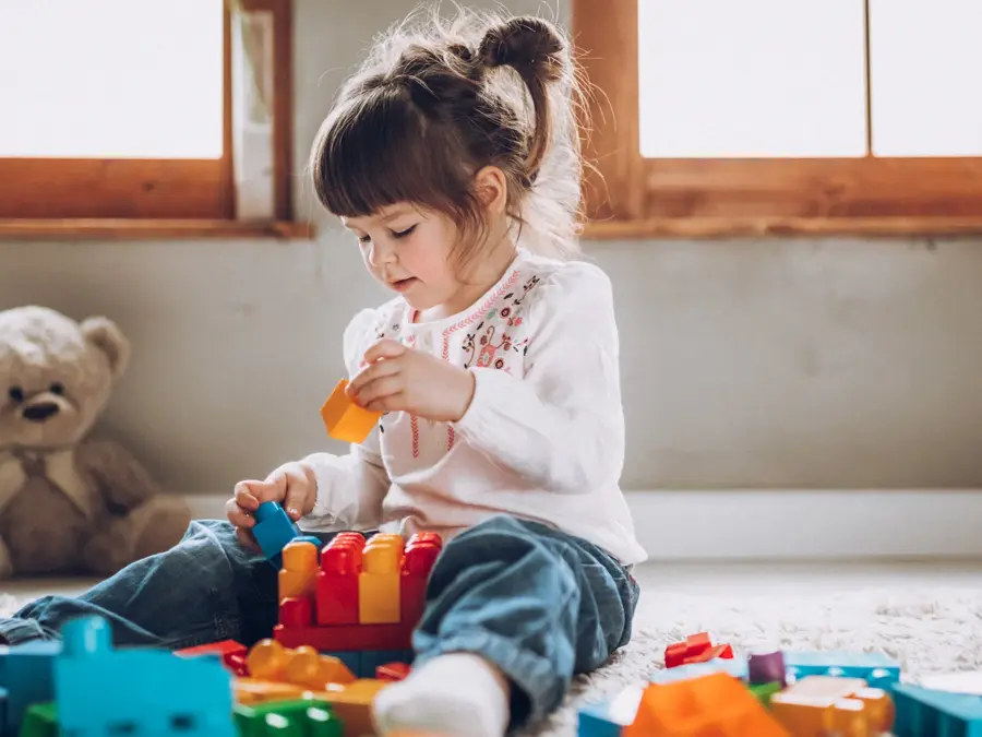 Sweet child playing with plastic blocks