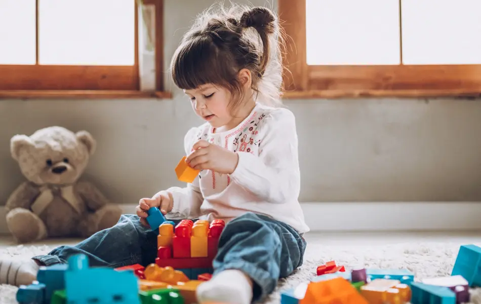 Sweet child playing with plastic blocks