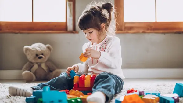 Sweet child playing with plastic blocks