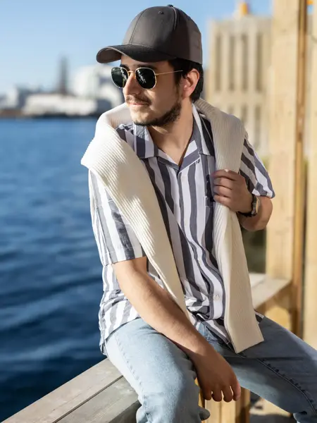 Mann som sitter ved vannkanten