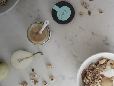 Storohonning, pære og nøtter på marmorbord