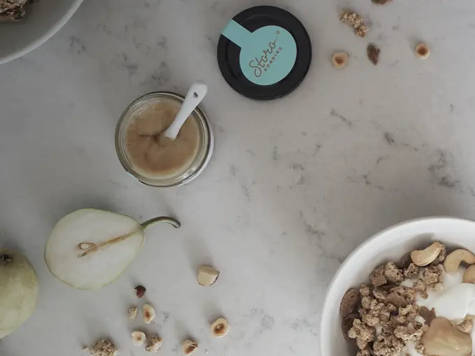 Storohonning, pære og nøtter på marmorbord