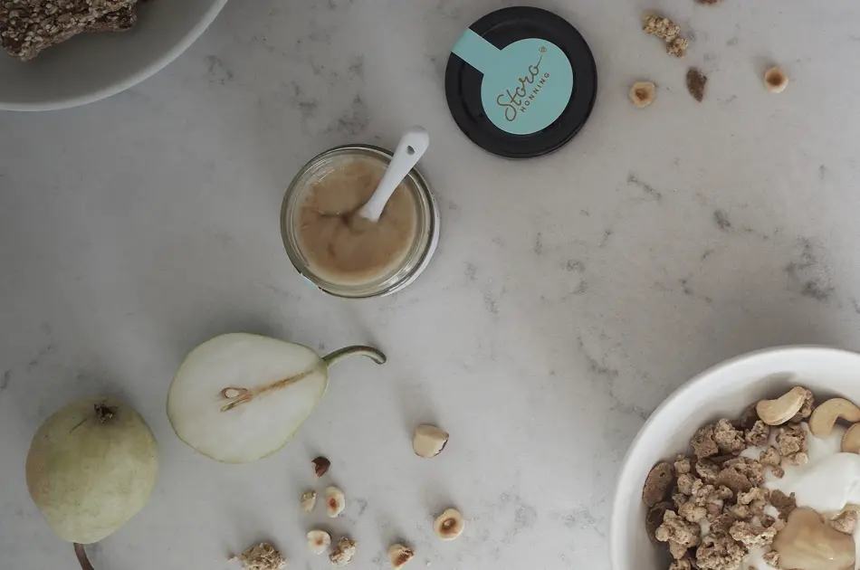 Storohonning, pære og nøtter på marmorbord