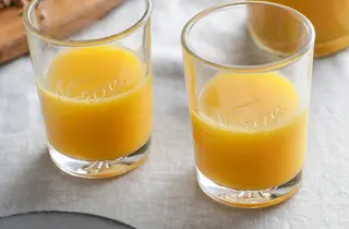 To glass med appelsinjuice på et bord.