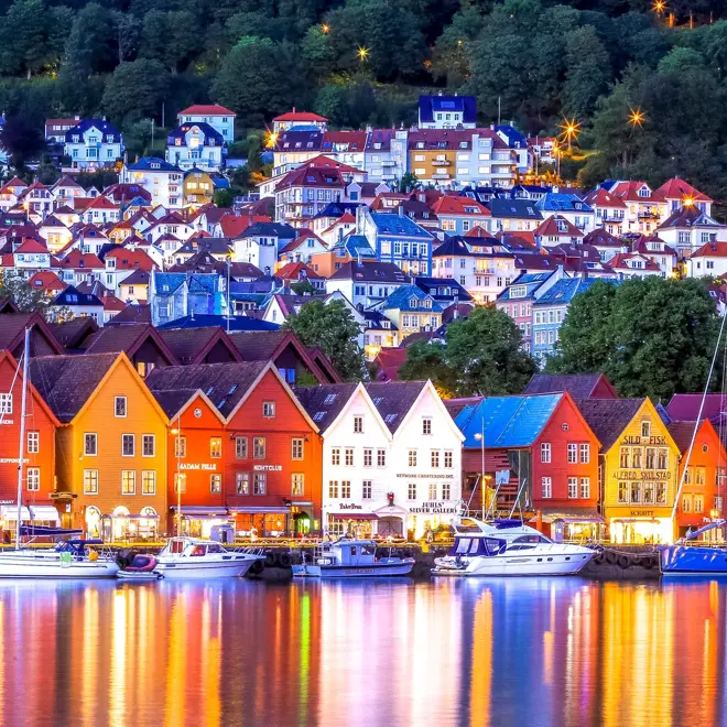 Bryggen i Bergen sett på avstand med bygningene som speiler seg i vannet