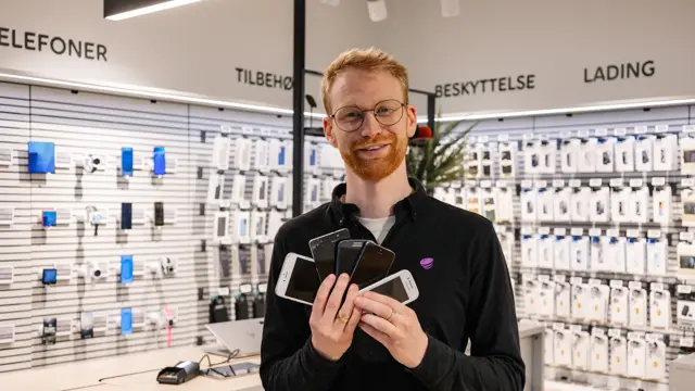 mann holder brukte mobiler i telia butikken