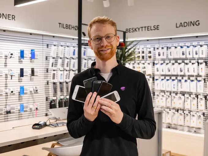 mann holder brukte mobiler i telia butikken