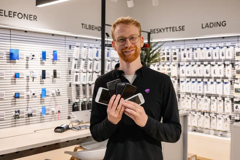 mann holder brukte mobiler i telia butikken