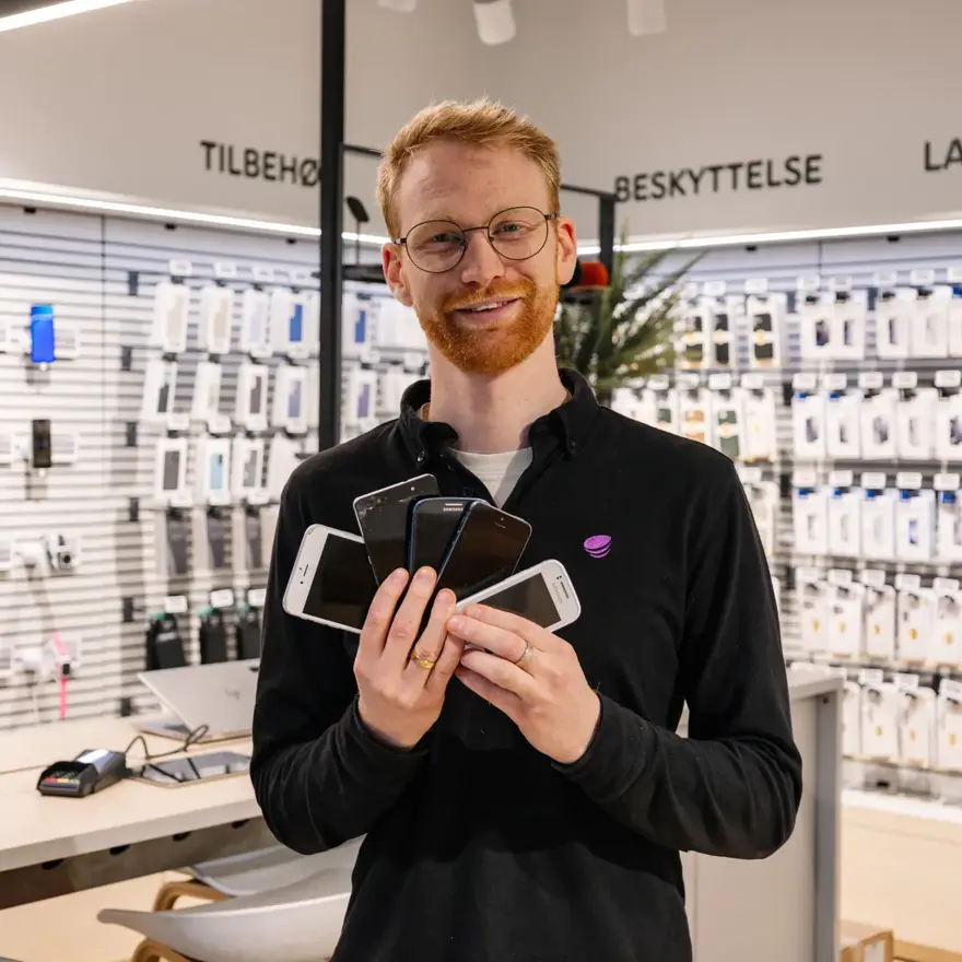 mann holder brukte mobiler i telia butikken