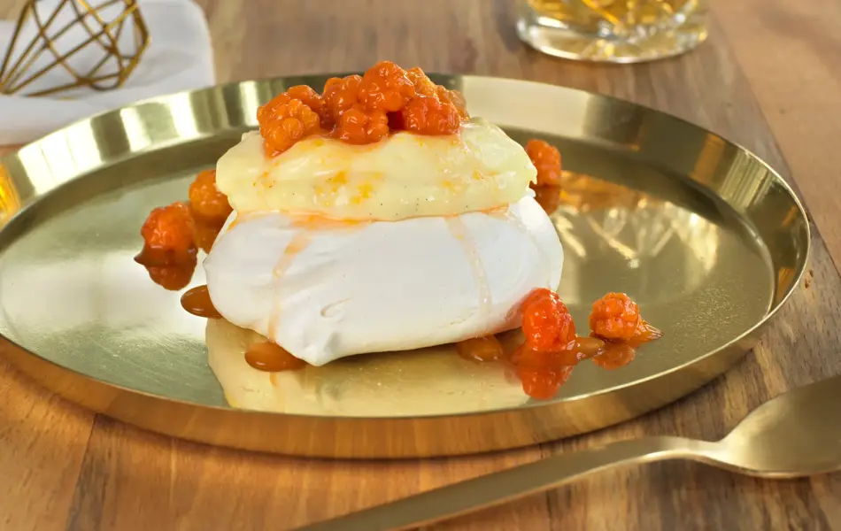 Minipavlova toppet med eggekrem og oransje multer på et gullfat