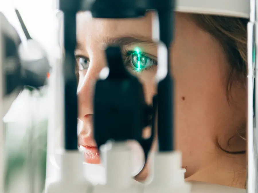 et barn som får øyet sitt sjekket av maskin hos øye klinikk