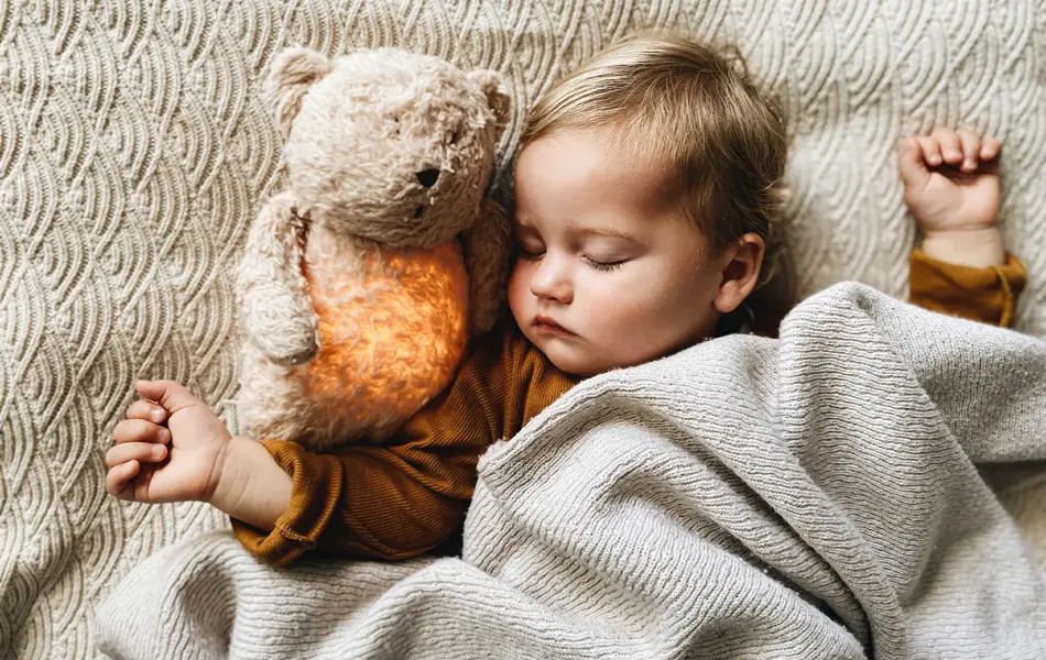 Barn med bamse som sover