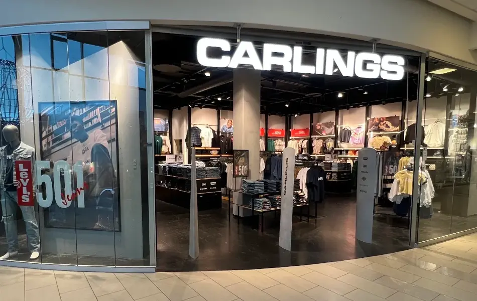 innendørs butikk med sort skilt og hvit tekst og klær