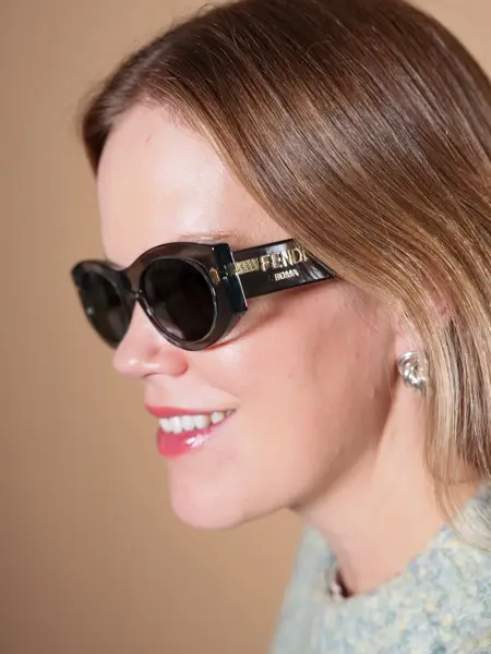 Dame med smale sorte Fendi solbriller med logo på siden