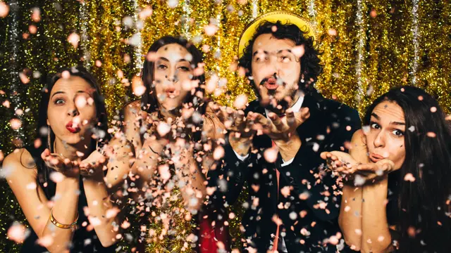 Vennegjeng blåser konfetti mot kamera