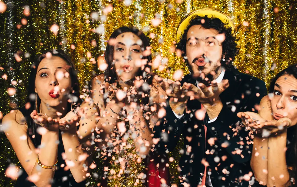 Vennegjeng blåser konfetti mot kamera