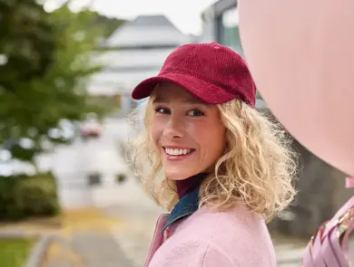 dame i rosa antrekk og holder rosa ballong