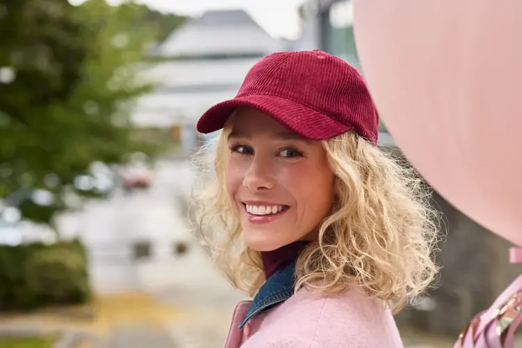 dame i rosa antrekk og holder rosa ballong