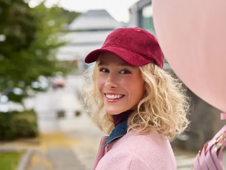dame i rosa antrekk og holder rosa ballong